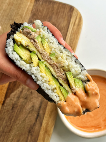 Sushi onigirazu dipped in sriracha mayonnaise.