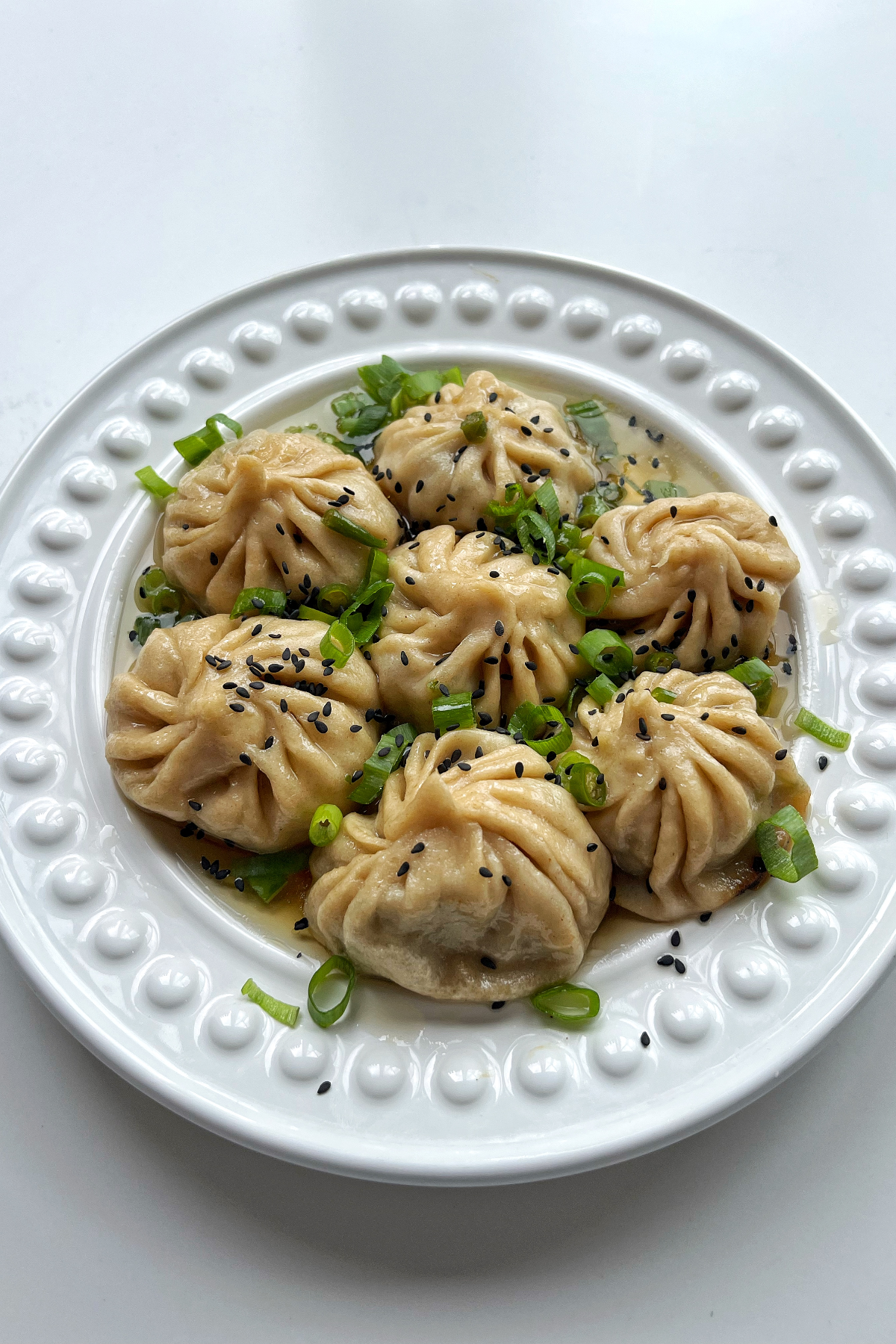 Pan fried lemongrass beef dumplings in a white bowl.