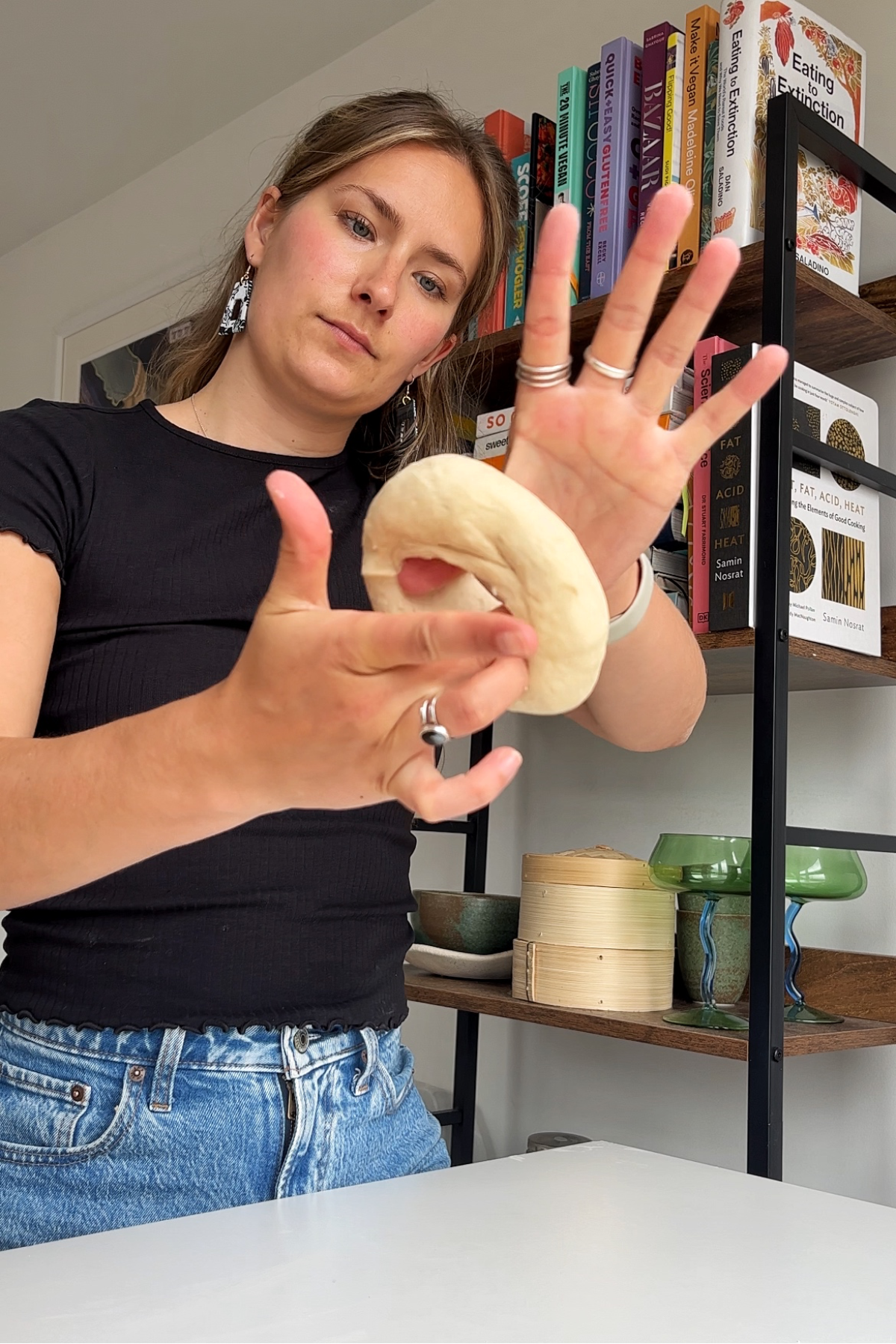 Rolling the dough into a doughnut using your fingers and hands.
