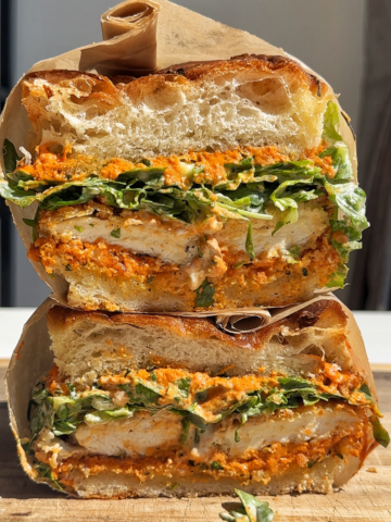 Stacked crunchy chicken romesco focaccia sandwich.