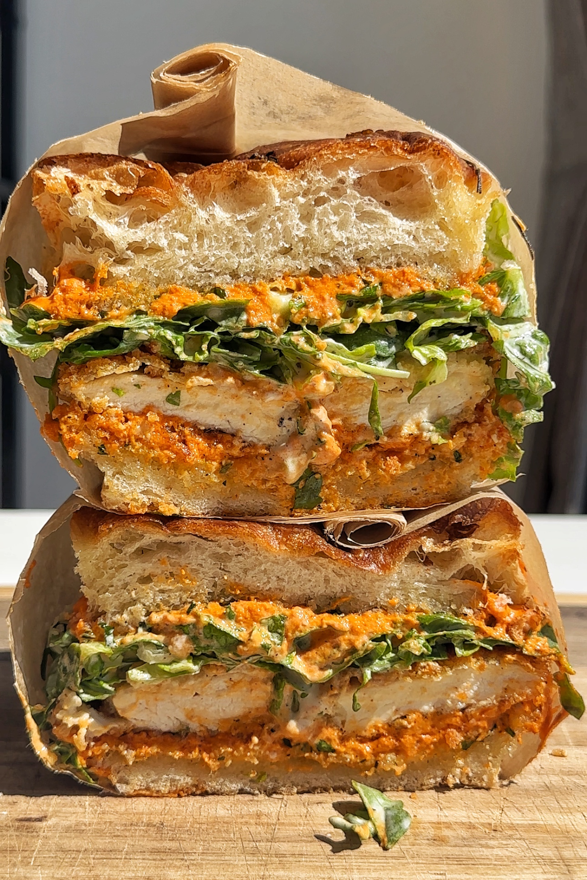 Stacked crunchy chicken romesco focaccia sandwich.