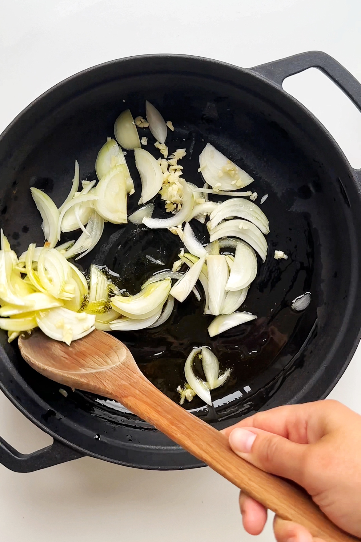 Frying onion and garlic in an ovenproof pan.