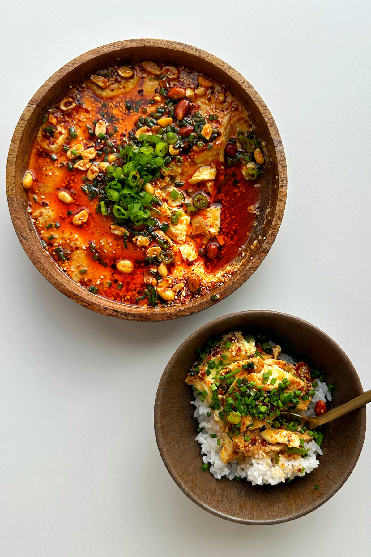 Steamed eggs in a wooden bowl and rice in a small bowl.