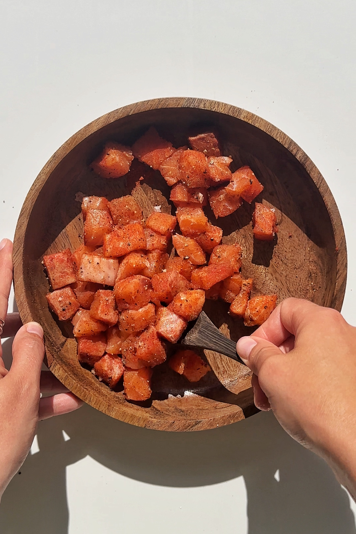 Marinating cubes of salmon.