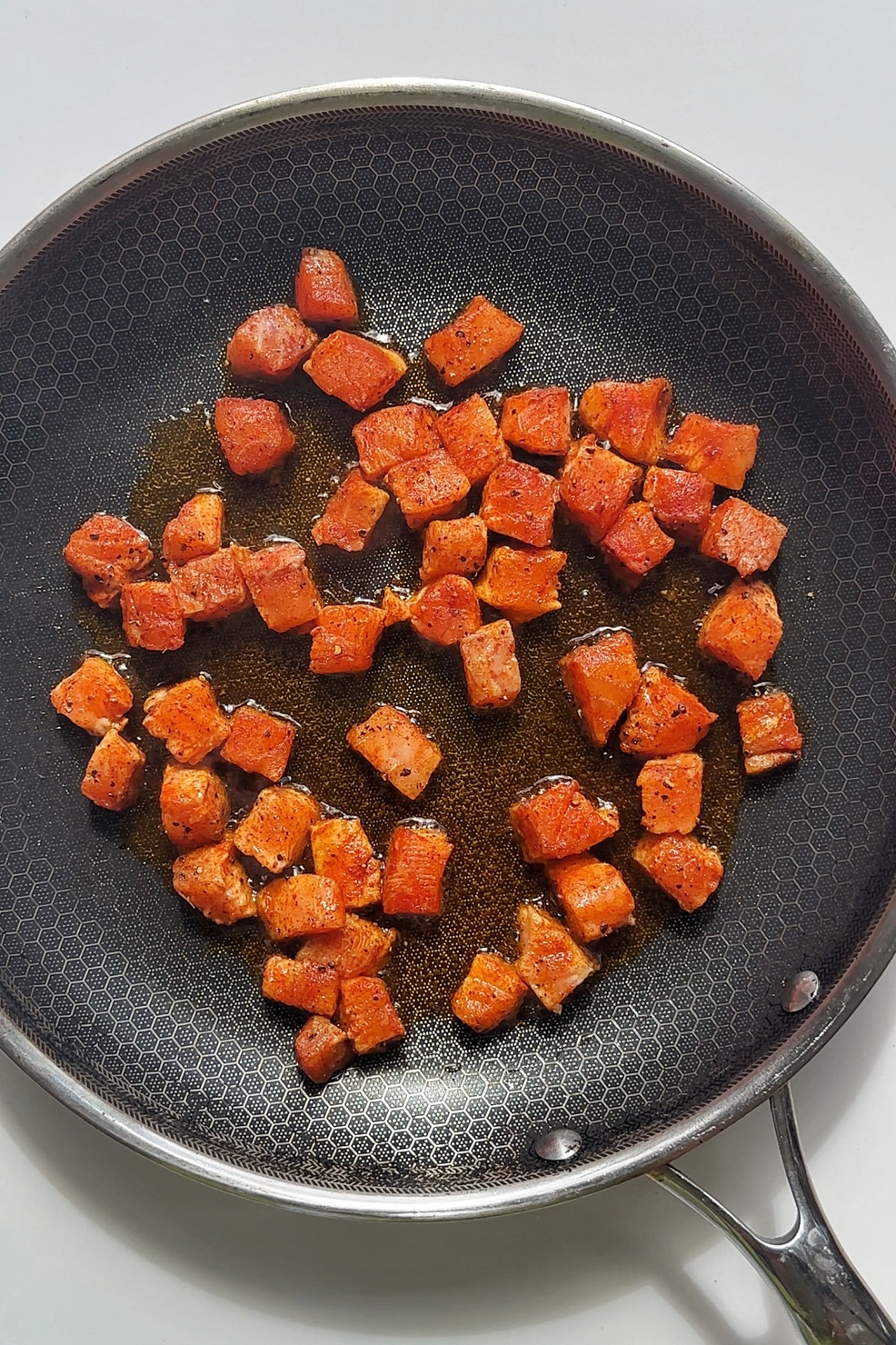 Frying cubes of salmon.