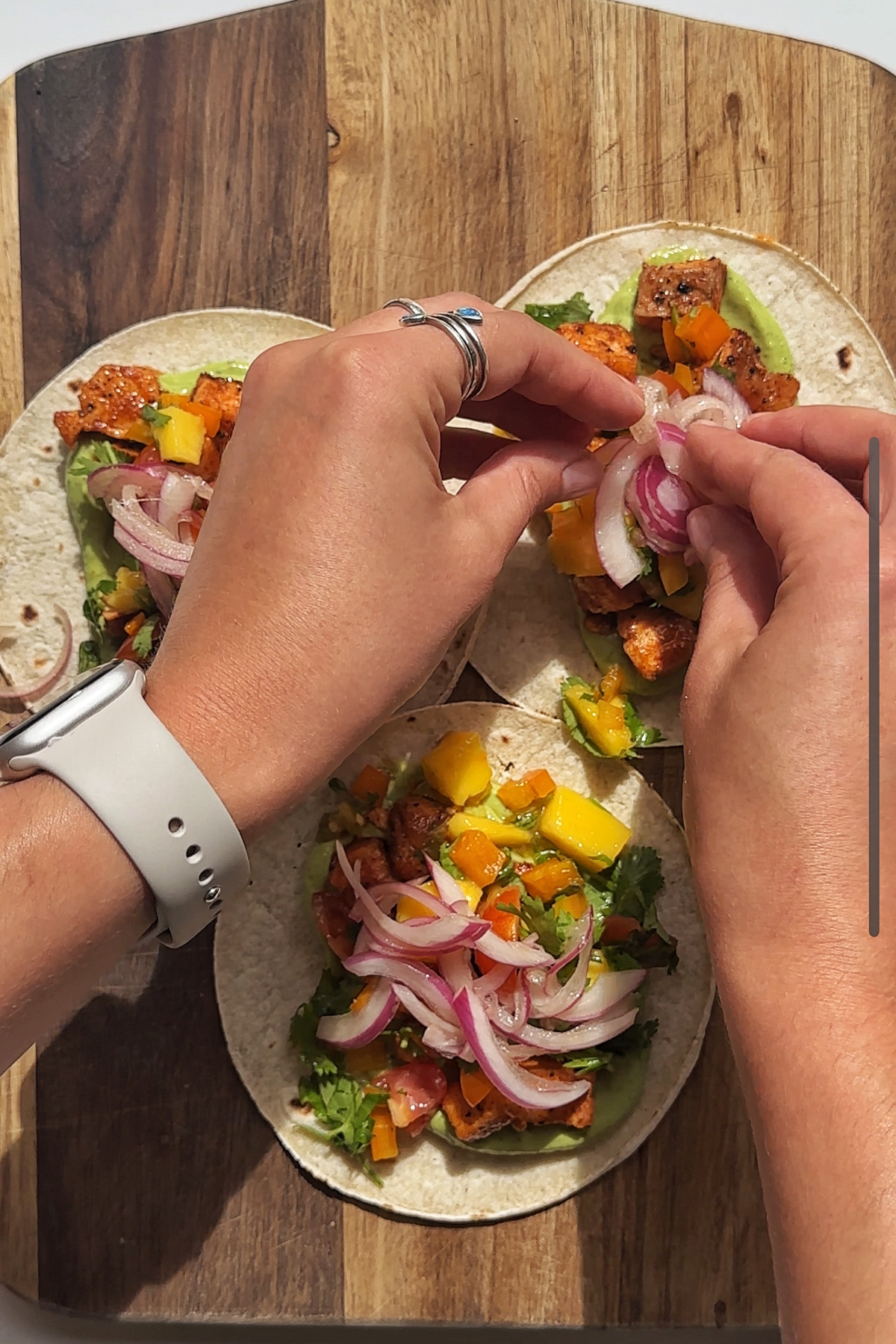 Assembling fish tacos with mango salsa.