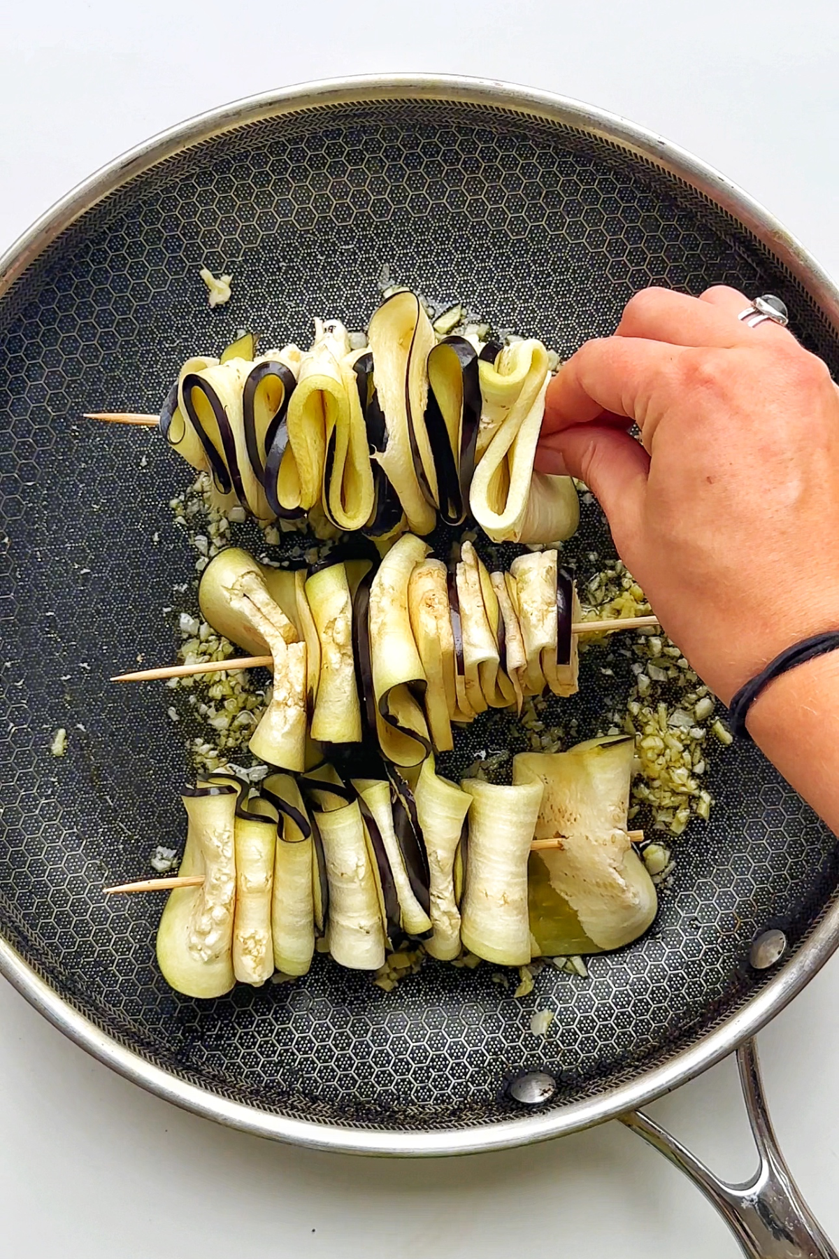 Frying the skewers in a non-stick pan.