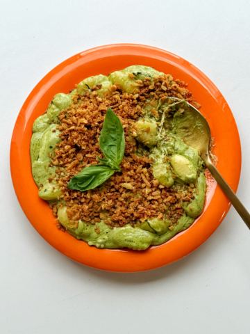 Pesto gnocchi with golden spoon.