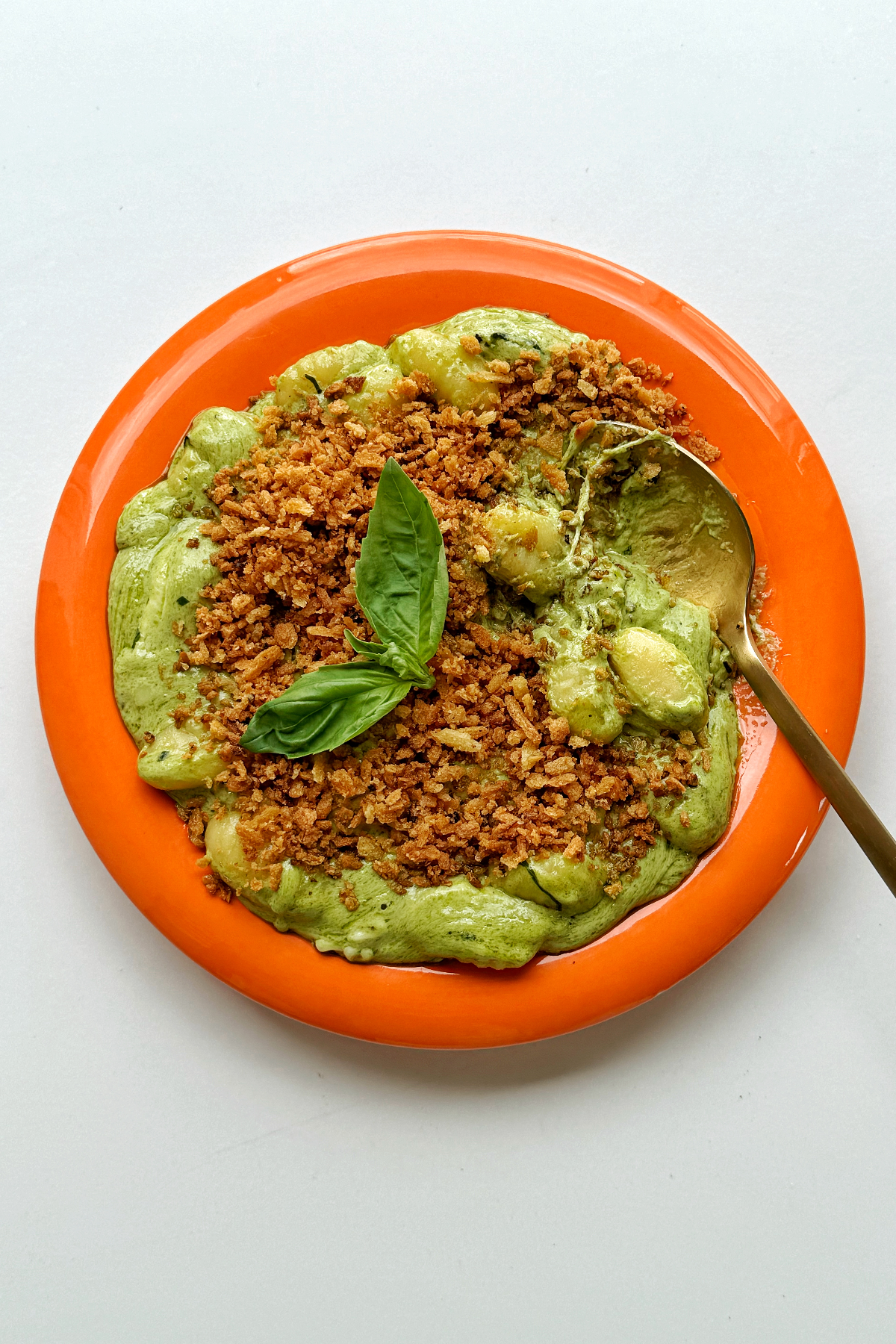Pesto gnocchi with golden spoon.