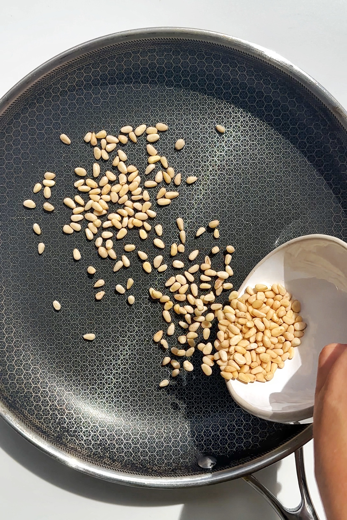 Toasting pine nuts.