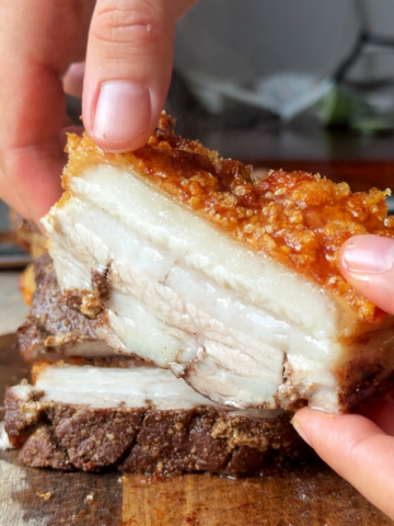 Holding up crispy pork belly to the camera.