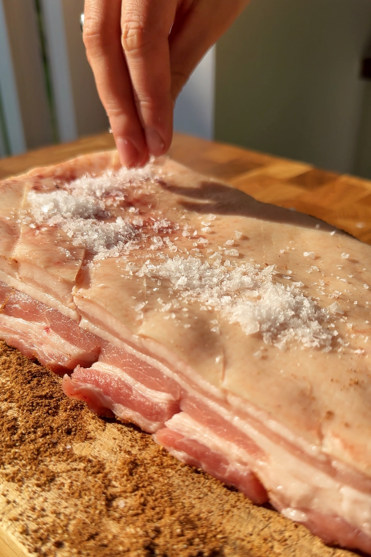 Salting the skin of pork belly.