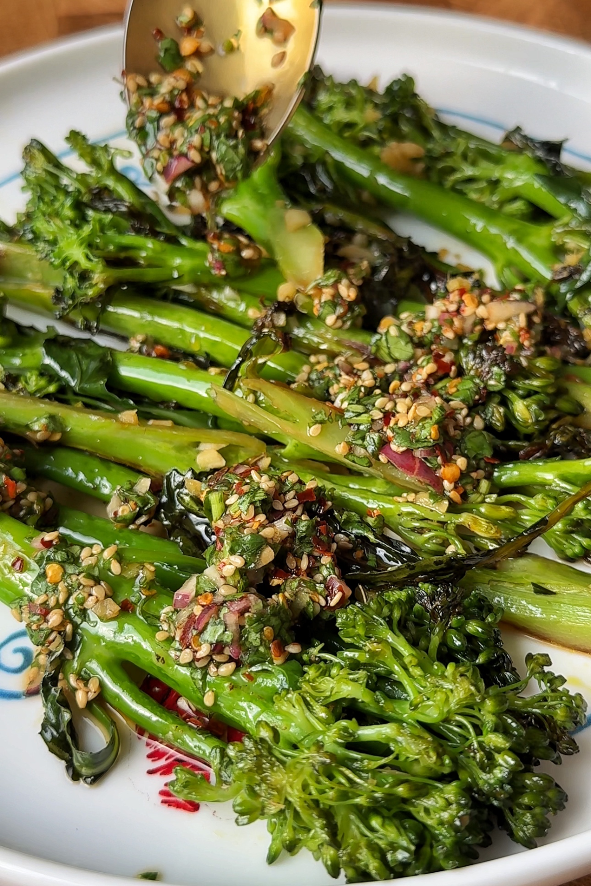 Adding the sauce onto the stir-fried broccolini.