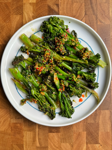 Top down shot of stir-fried broccolini (tender stem broccoli) with a spicy sauce.