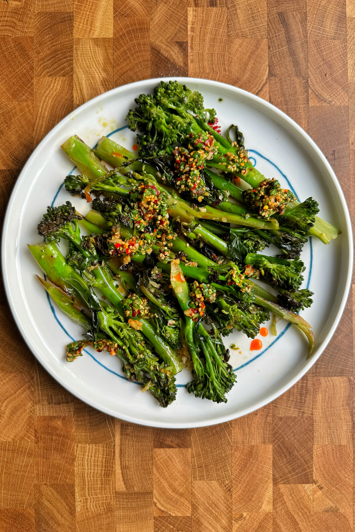 Top down shot of stir-fried broccolini (tender stem broccoli) with a spicy sauce.