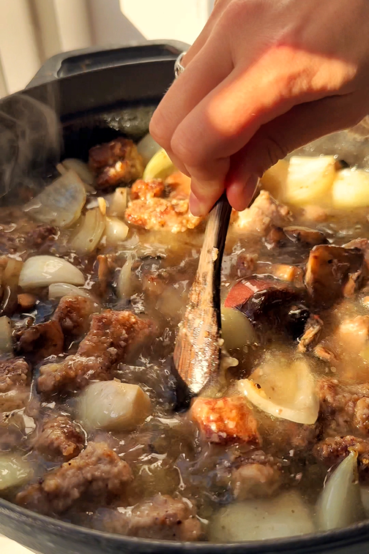 Adding beef stock to beef stew.