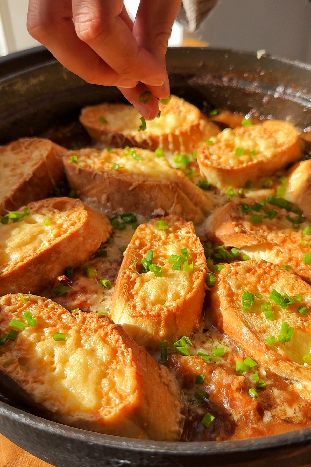 Topping the French onion casserole with chives.