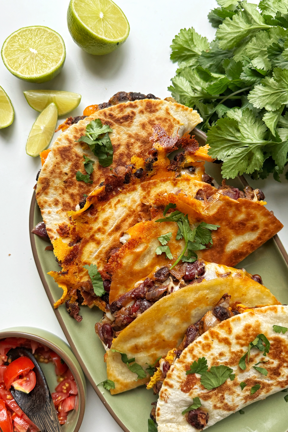 Black bean tacos stacked on a green platter.