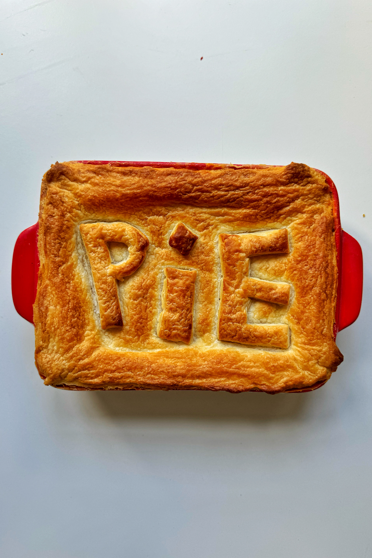 Chicken pot pie using puff pastry with the word pie on top of the pastry.