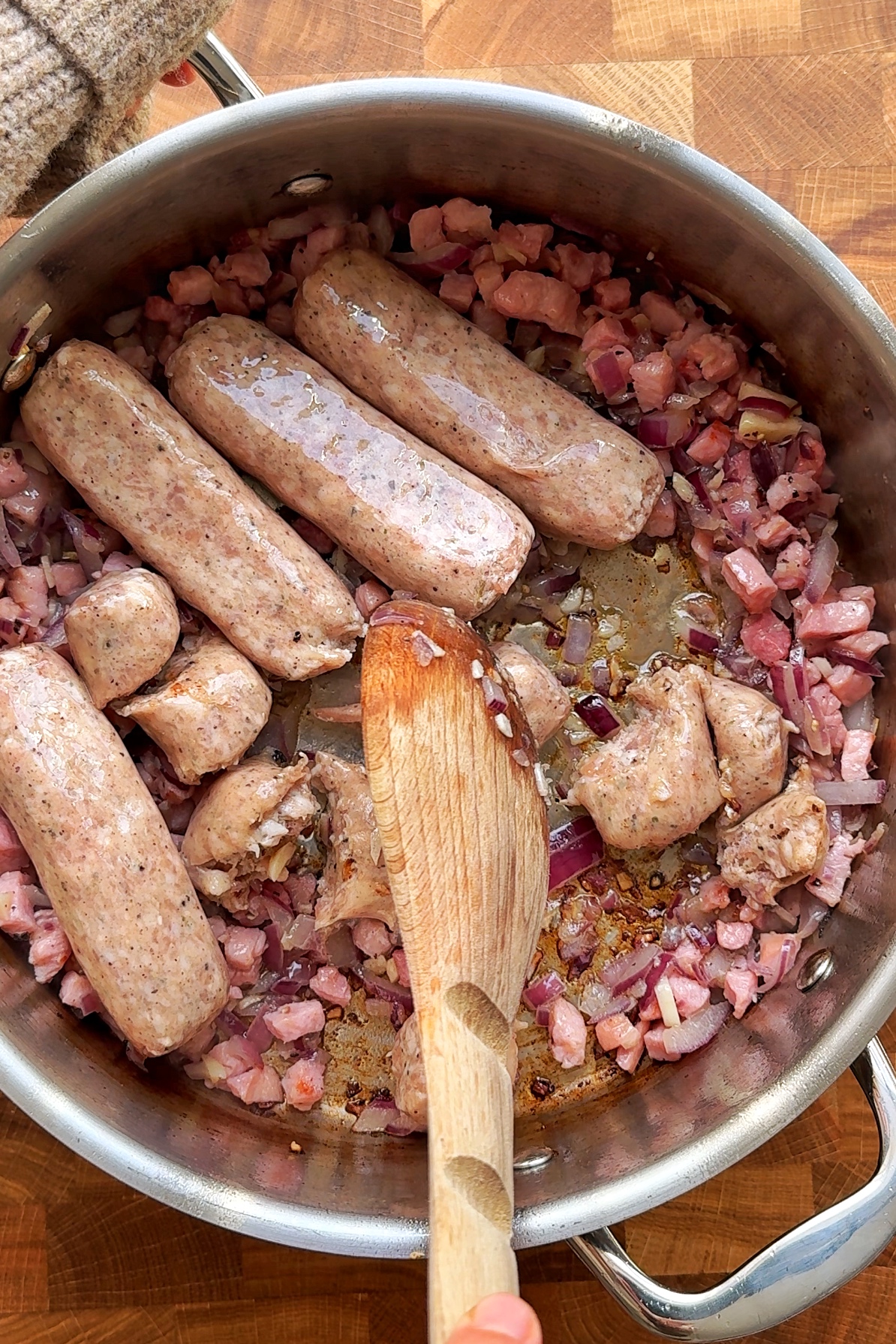 Frying sausages in a pan for sausage stew.