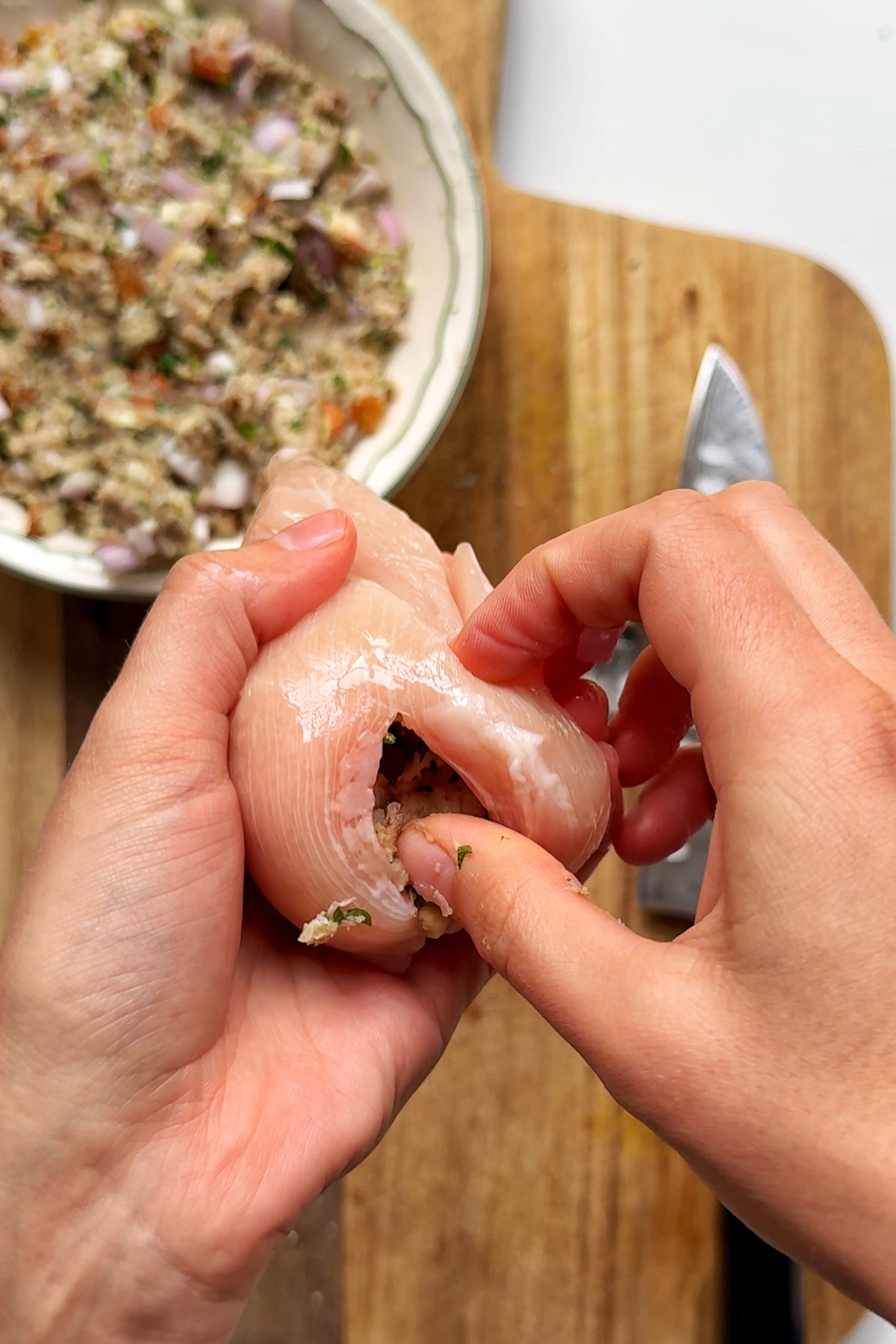 Stuffing the chicken breast with stuffing.