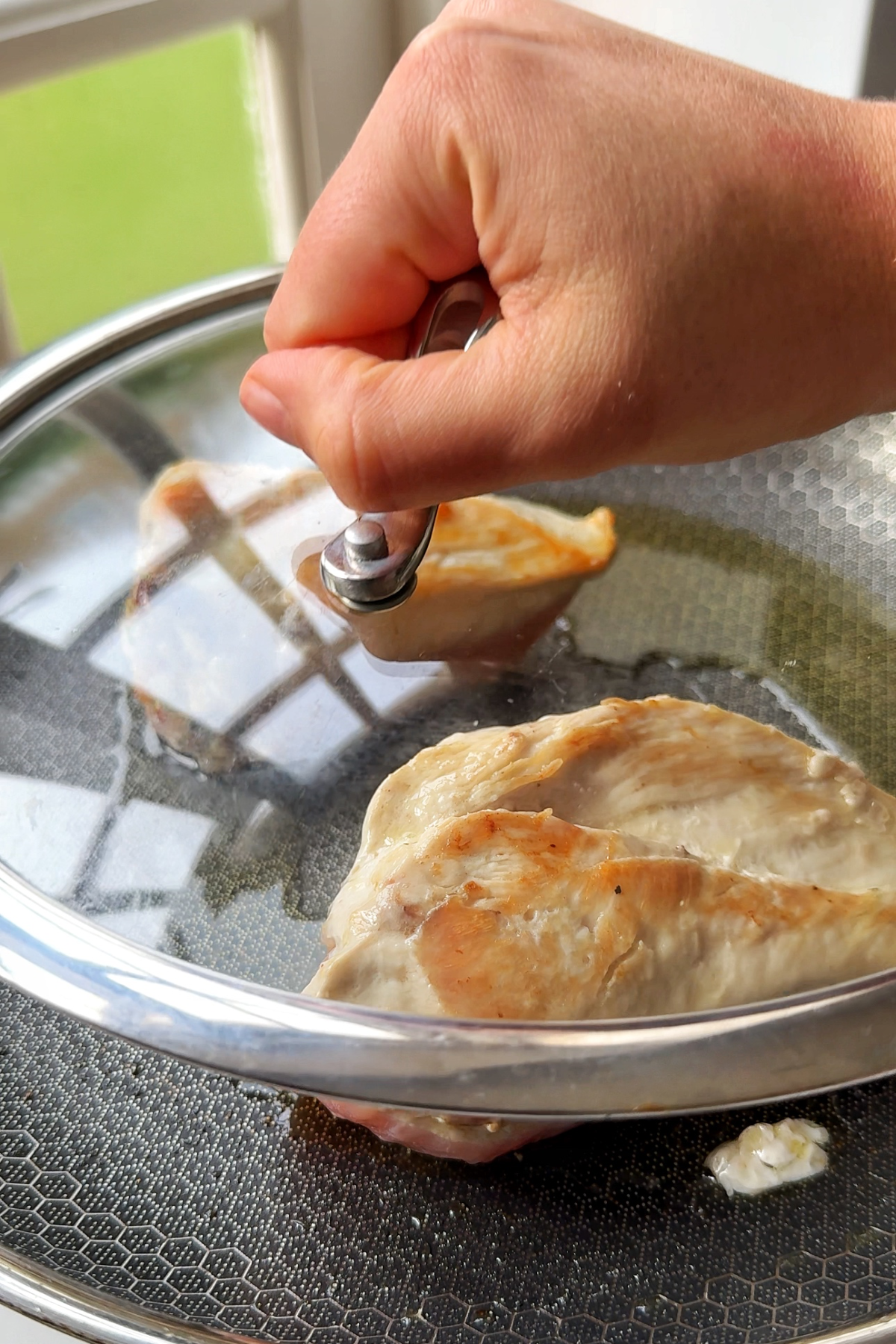 Frying the stuffed chicken breast with stuffing in a black skillet.
