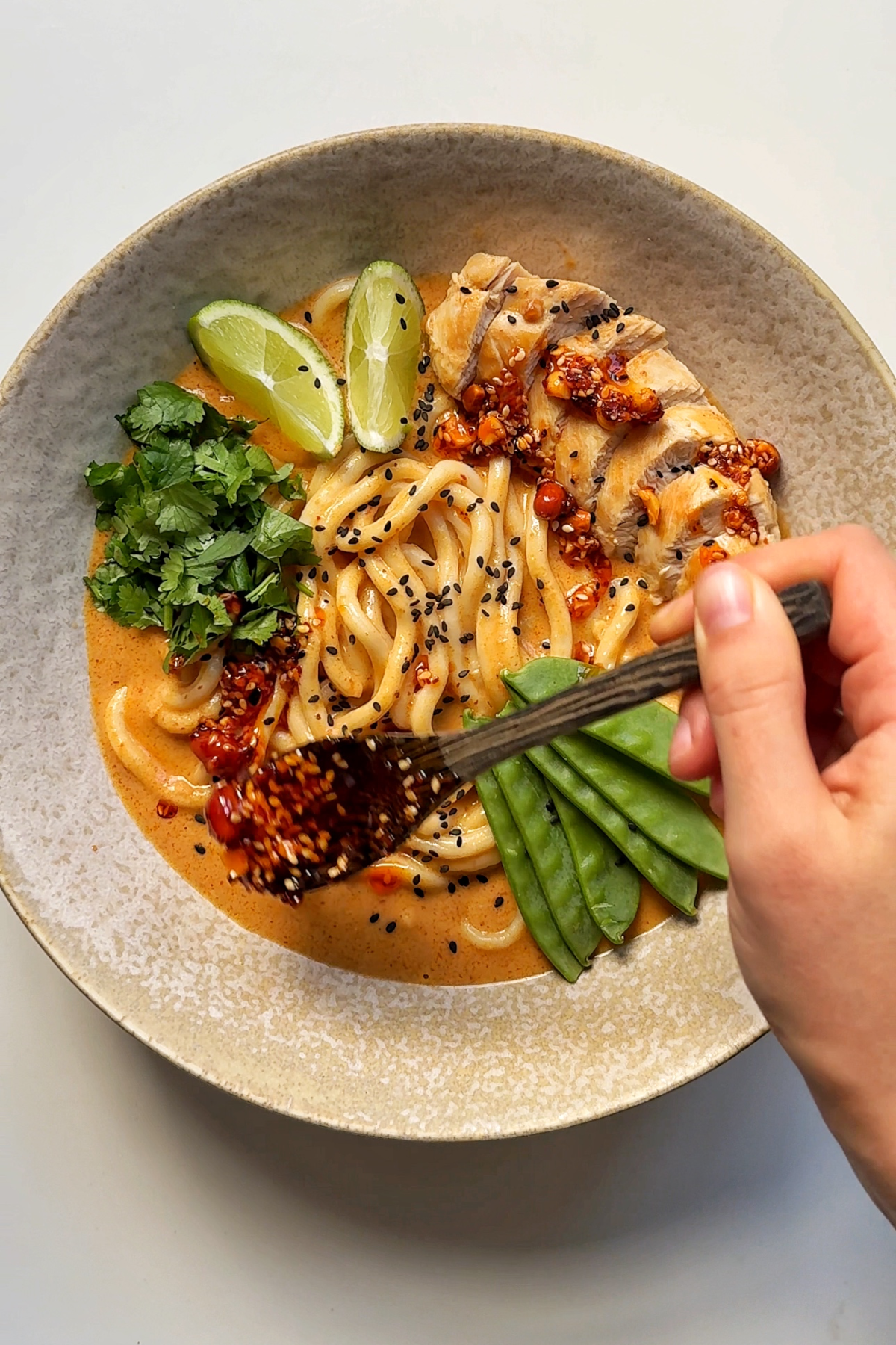 Serving up peanut butter noodles topped with chilli oil, coriander, chicken.