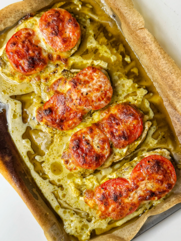 Baked pesto chicken on a tray.