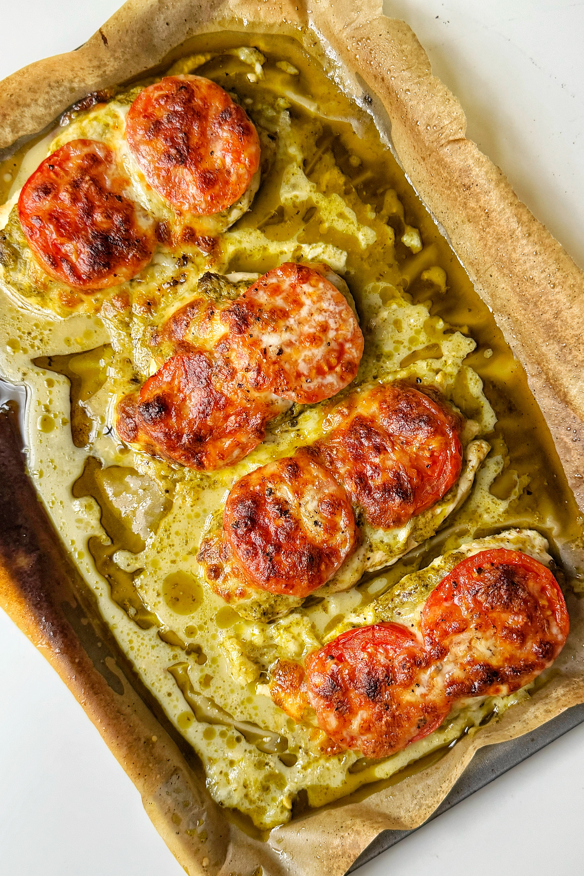 Baked pesto chicken on a tray. 