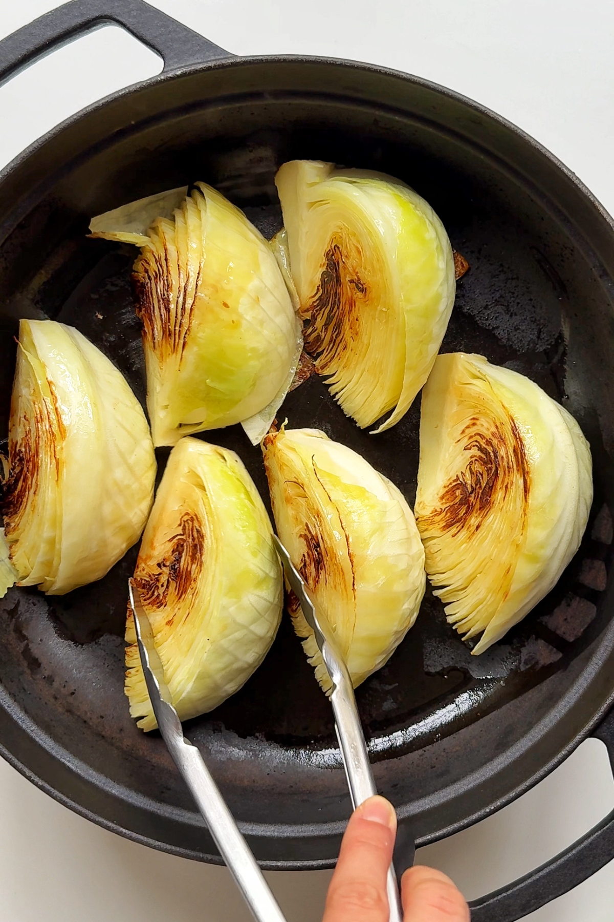 Frying cabbage in black cast iron pan.