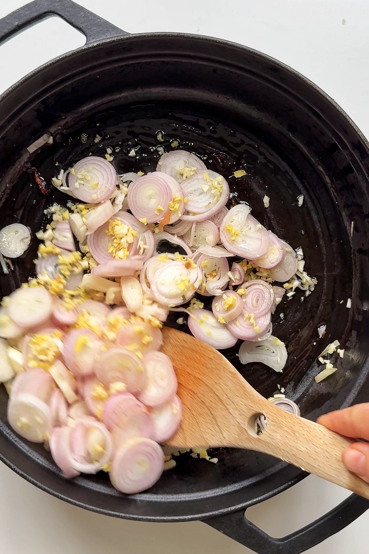 Frying shallots garlic and ginger in pan.