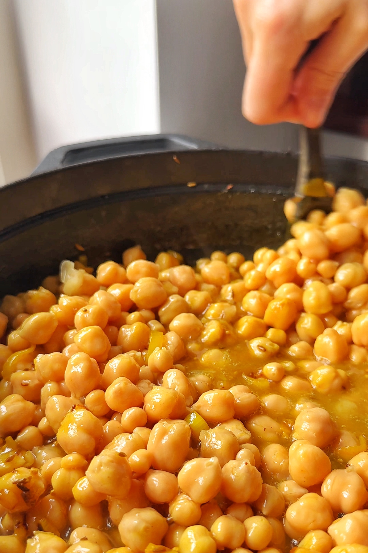 Adding chickpeas to the spinach dal mixture.