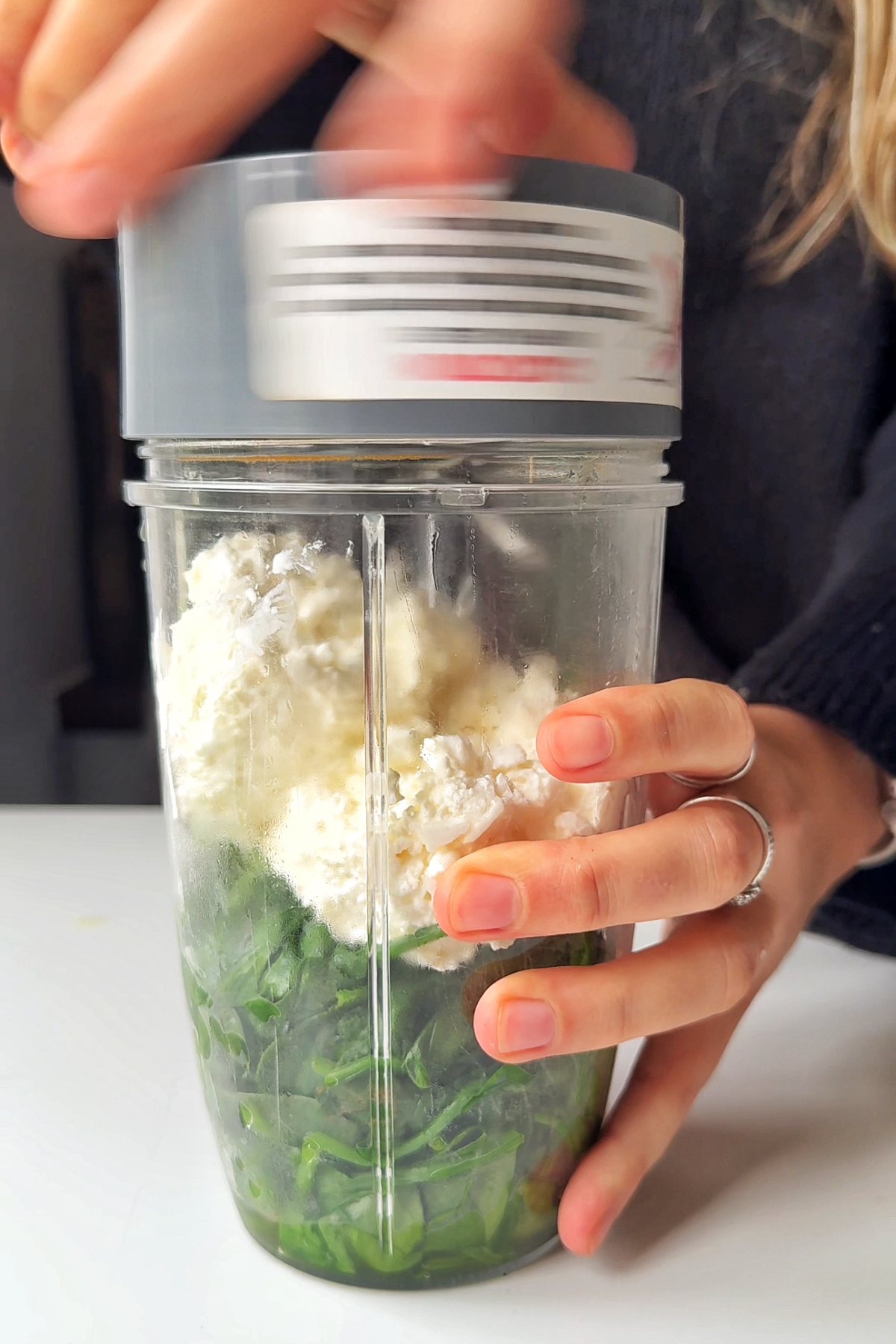Blending spinach with cottage cheese.