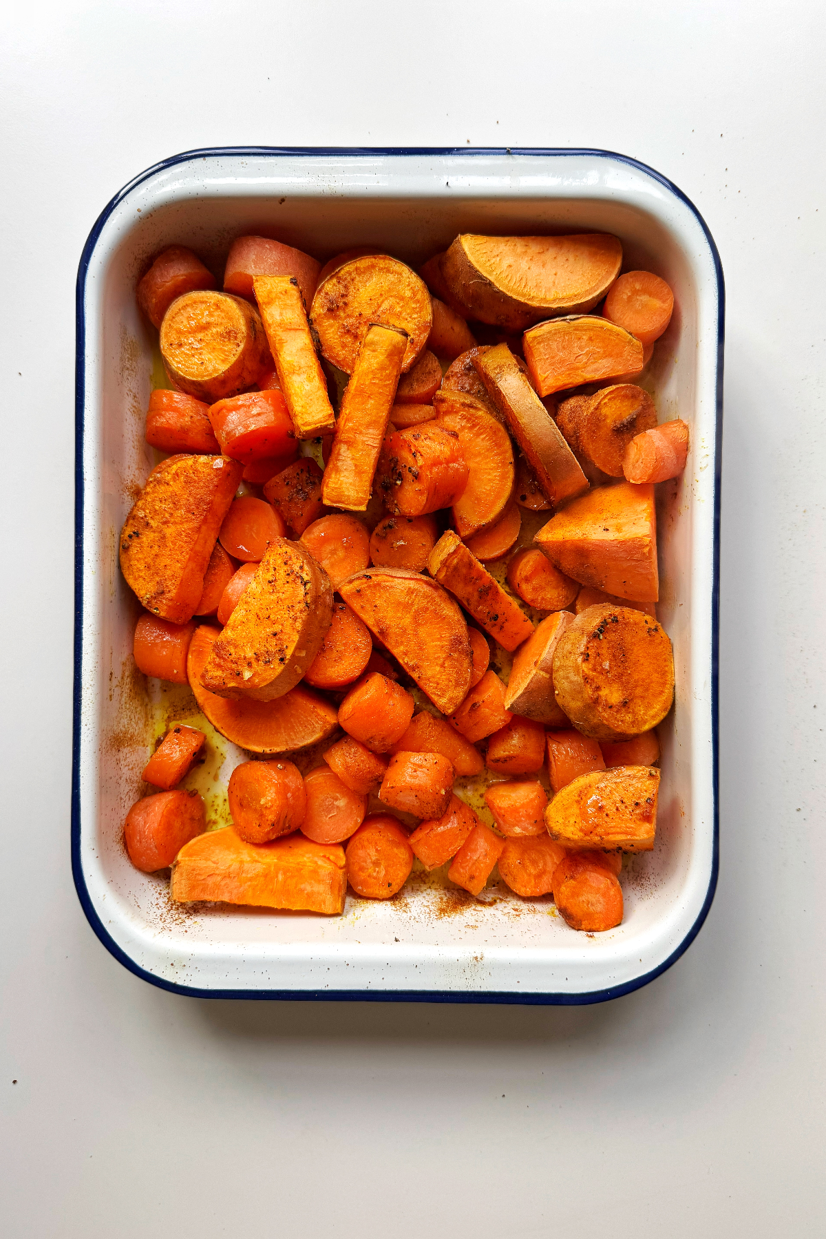 Roasting carrots and sweet potato in a tray.