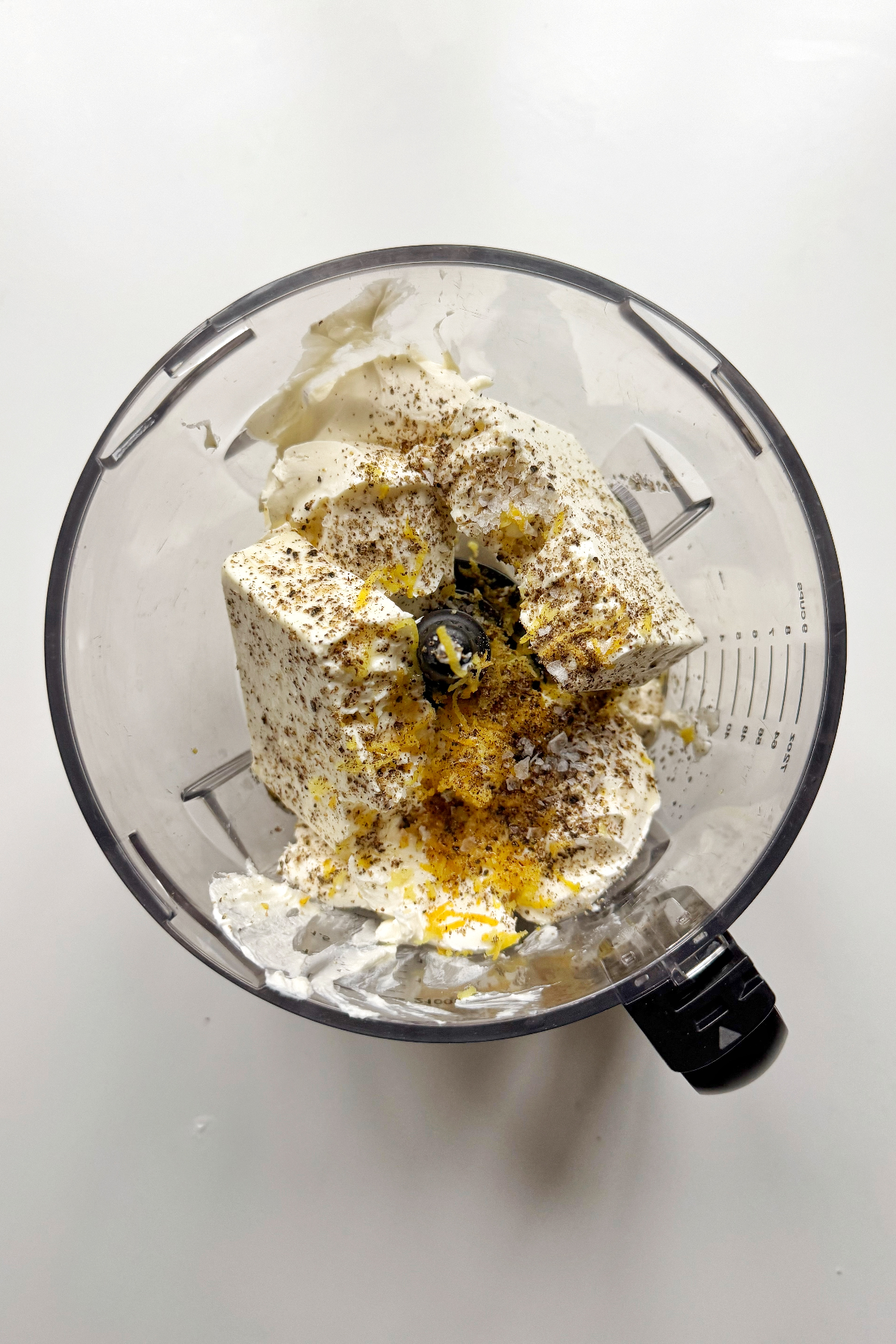 Placing the bruschetta dip ingredients into a food processor.