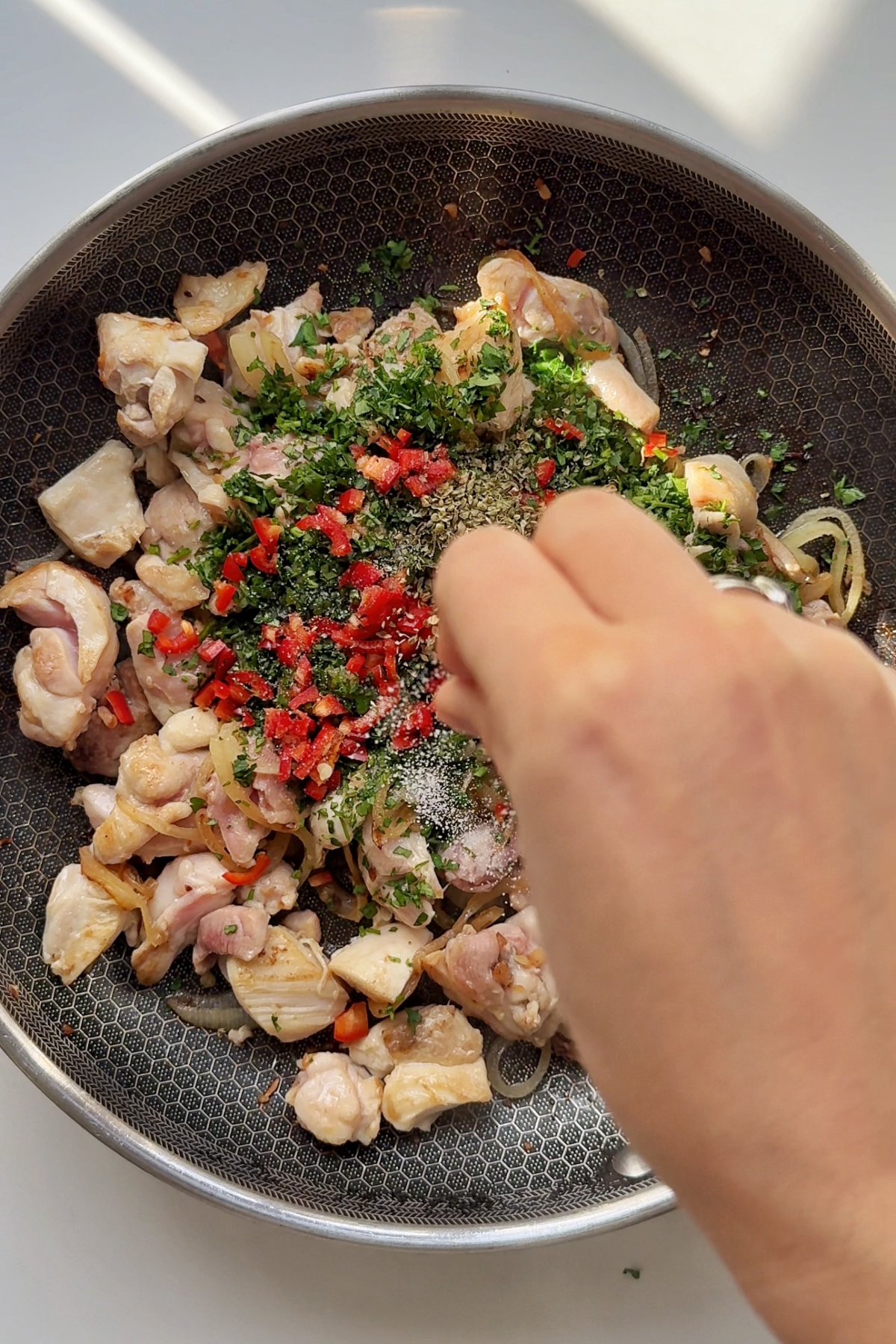 Adding chillies, parsley, and salt to the chicken pot pie filling.