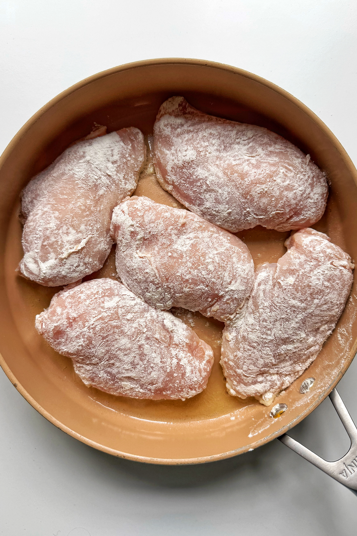 Frying chicken breast in a pan.