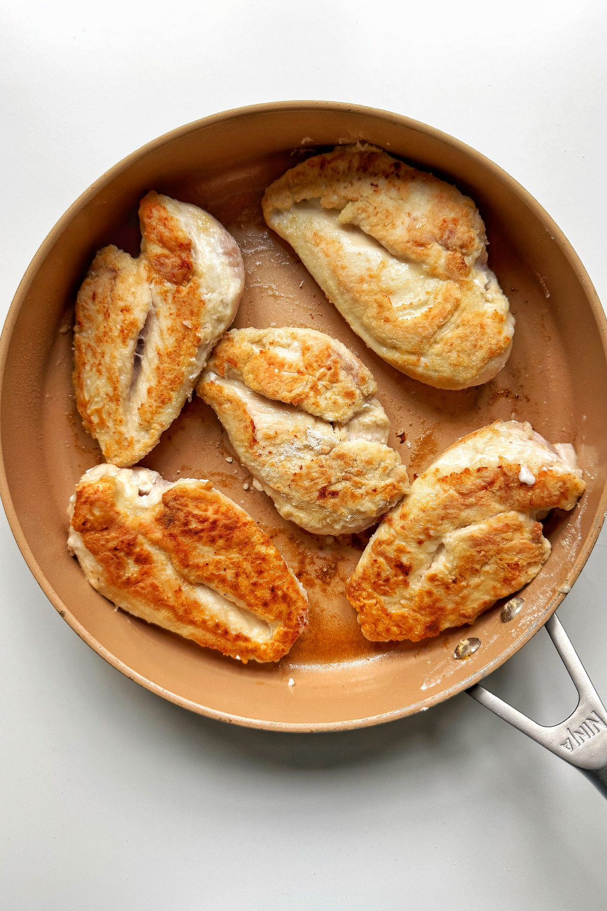Frying chicken breast in skillet.