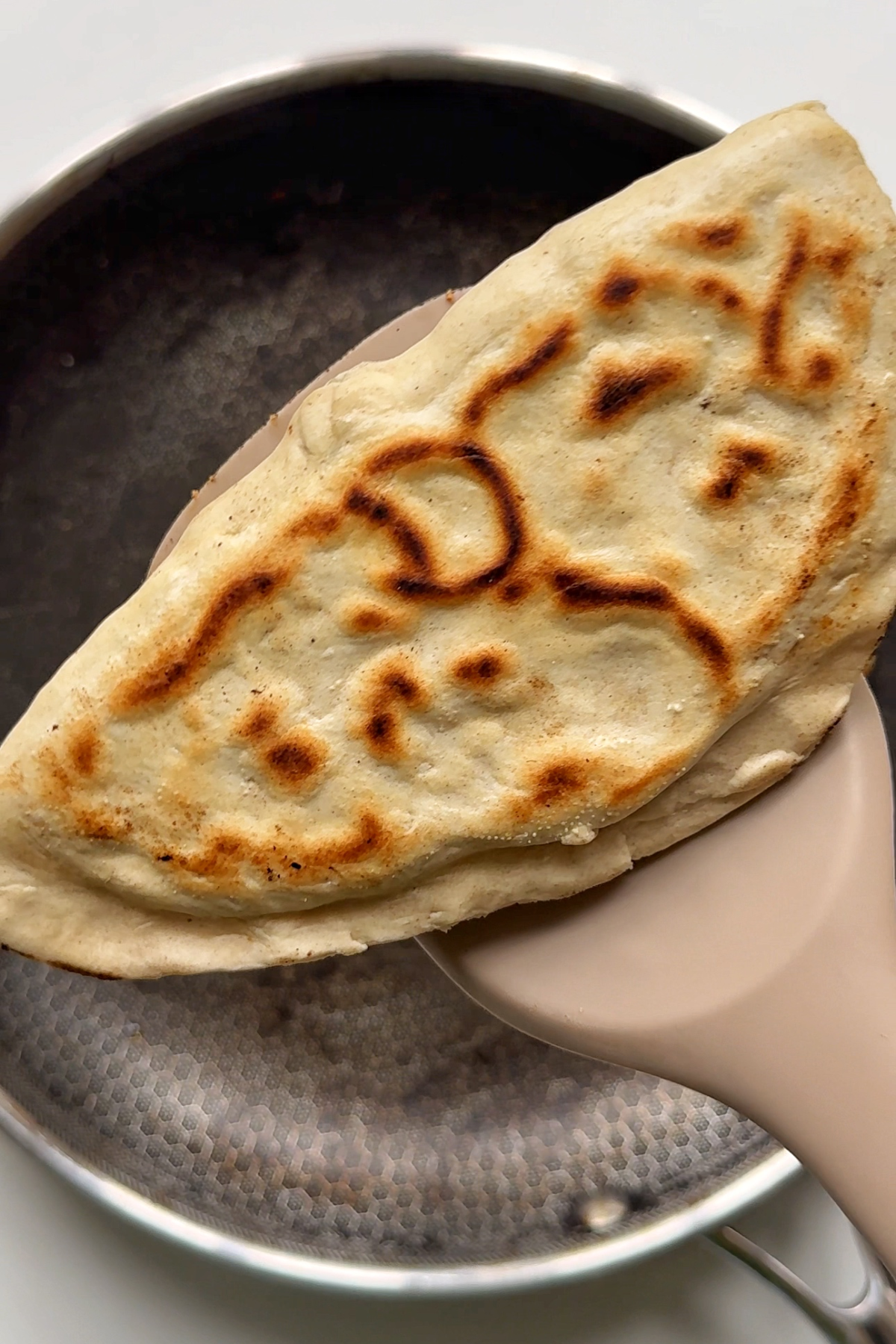 Removing the flatbread from the pan.