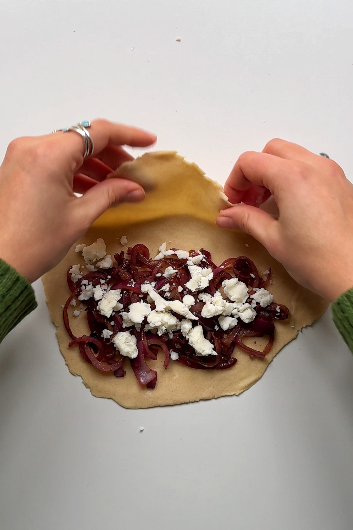 Filling the flatbread with red onion and goats cheese.