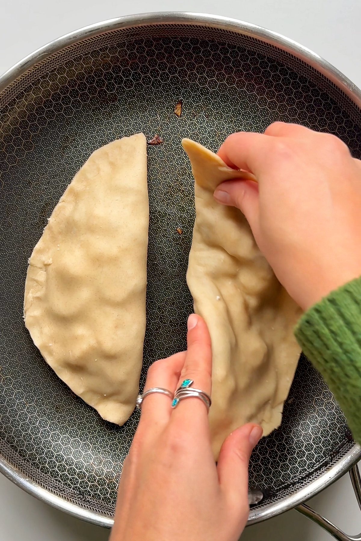 Frying the gözleme in a pan.