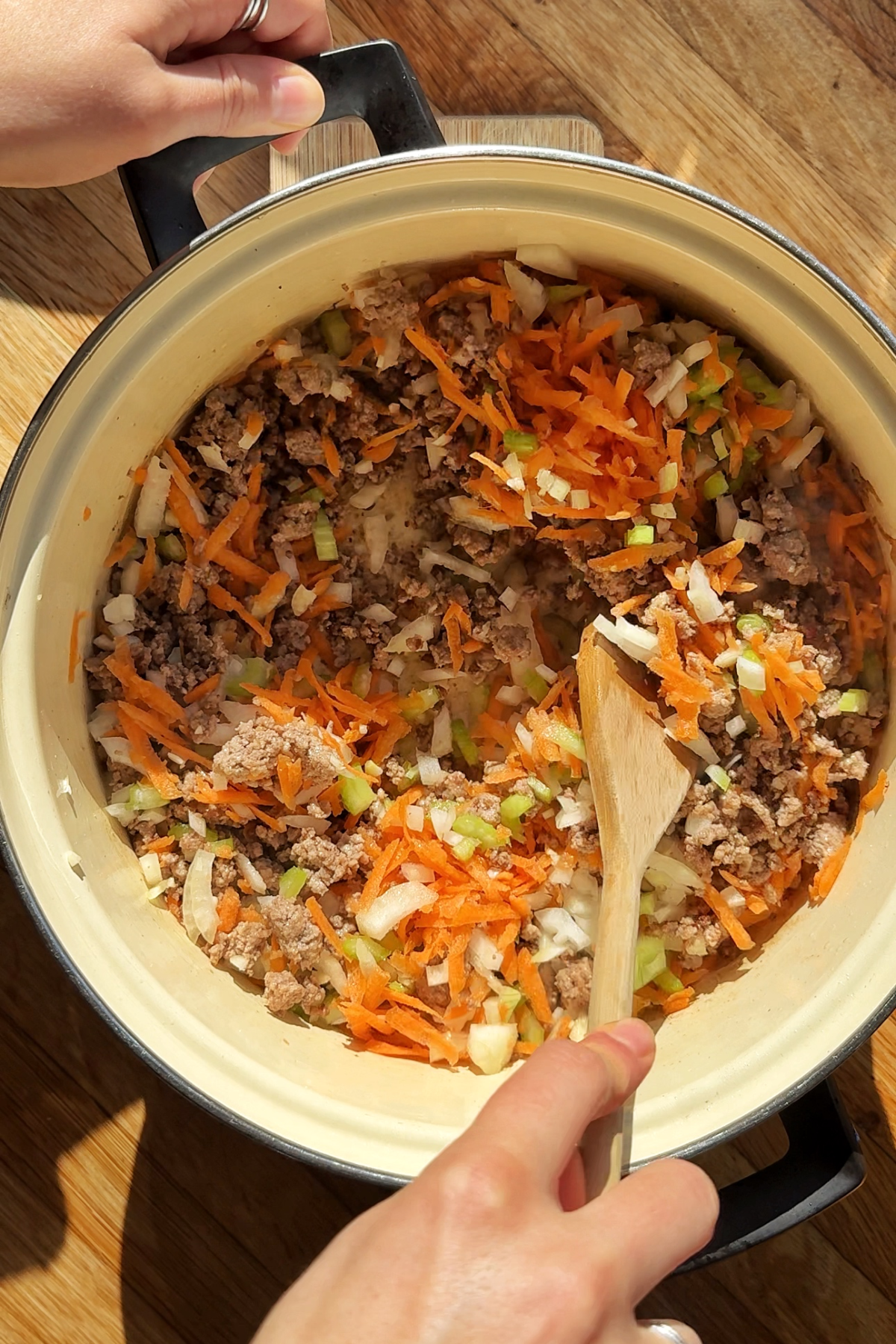 Adding celery carrot onion and garlic to the lamb mince in pot.