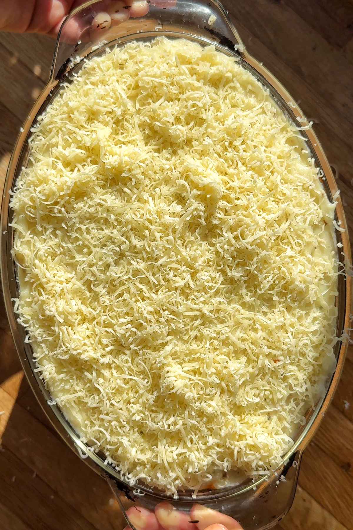 Topping the shepherds pie with cheese.