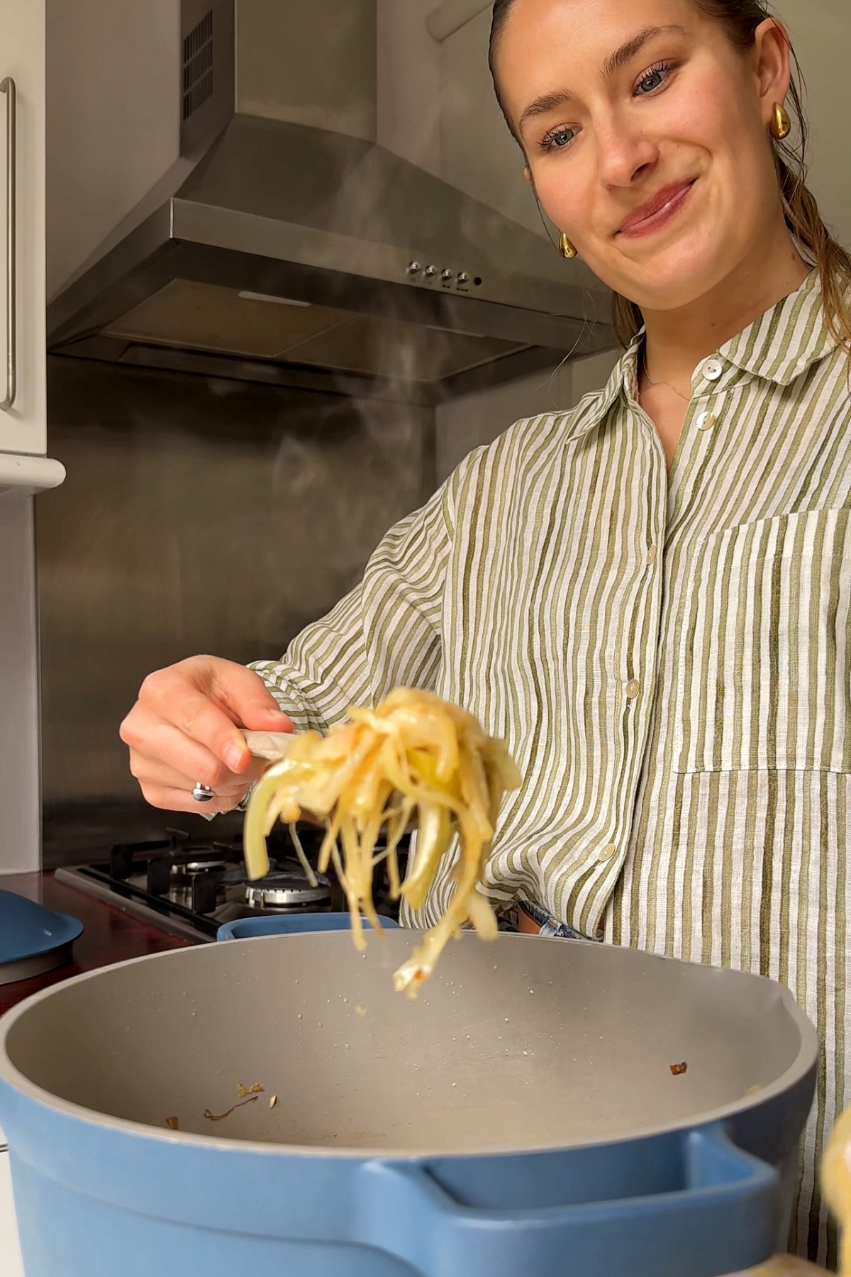 Frying onions in a pan until they're soft.