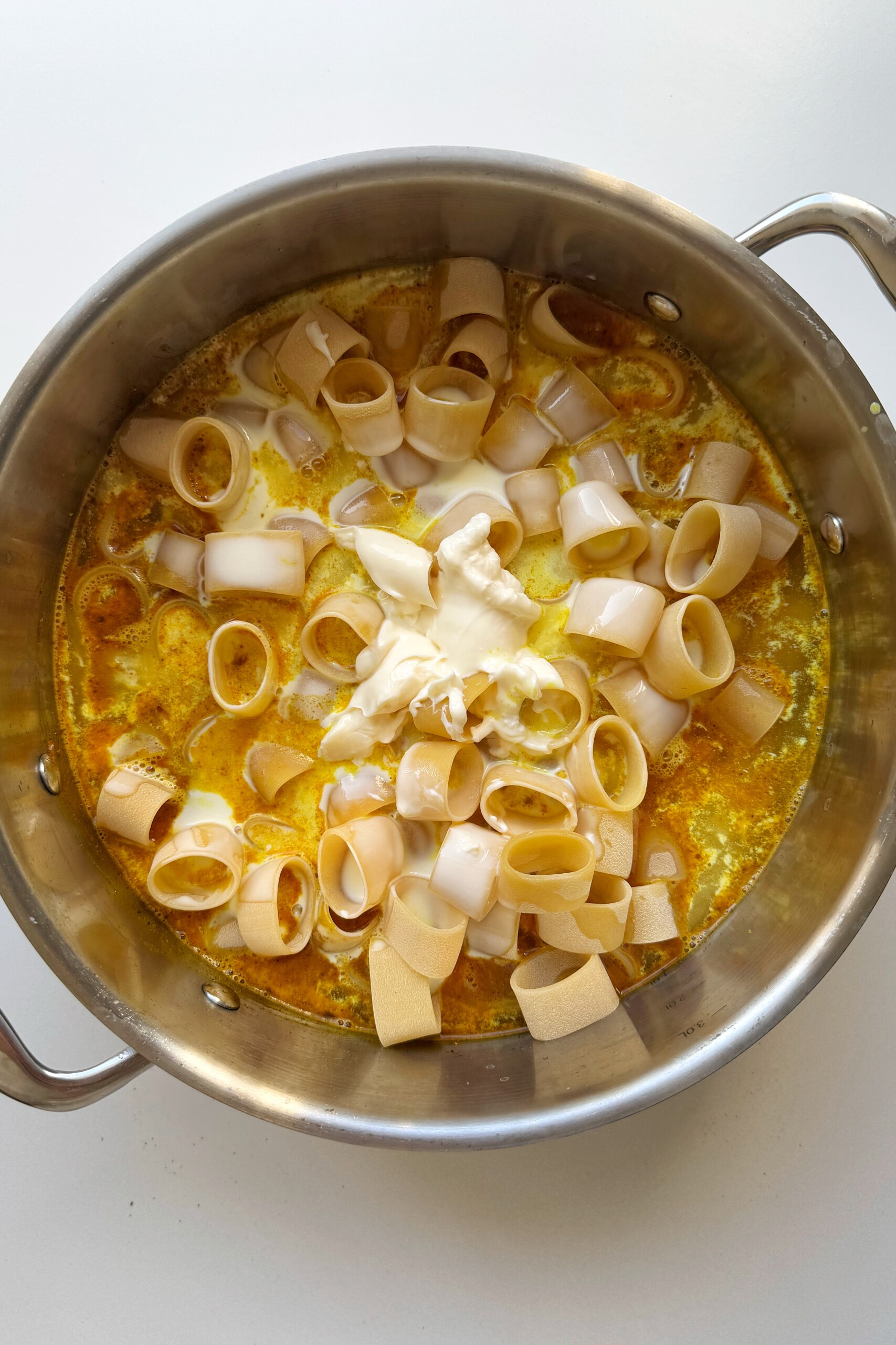 Cooking curry pasta in a pot.
