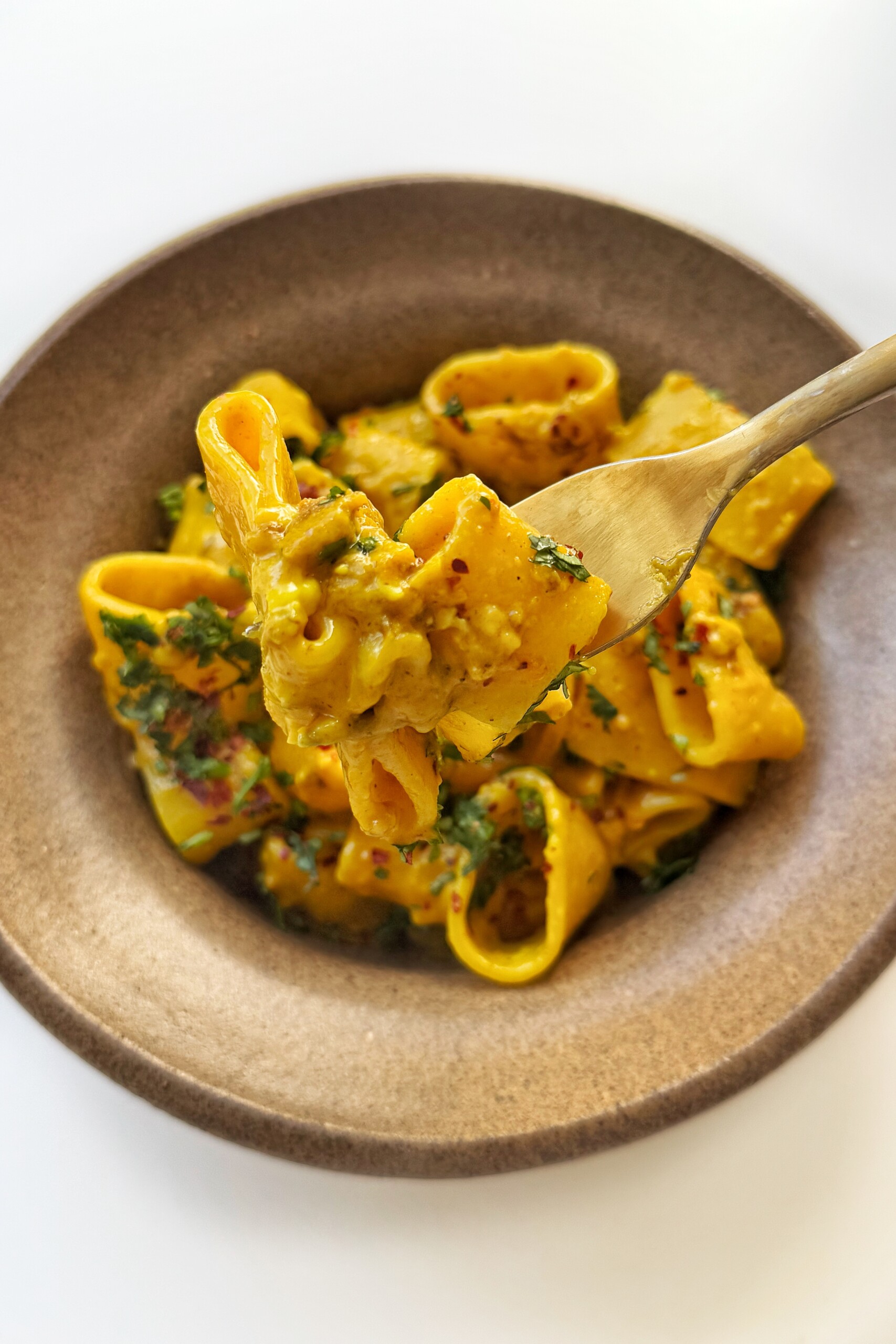 close up of curry pasta on a fork.