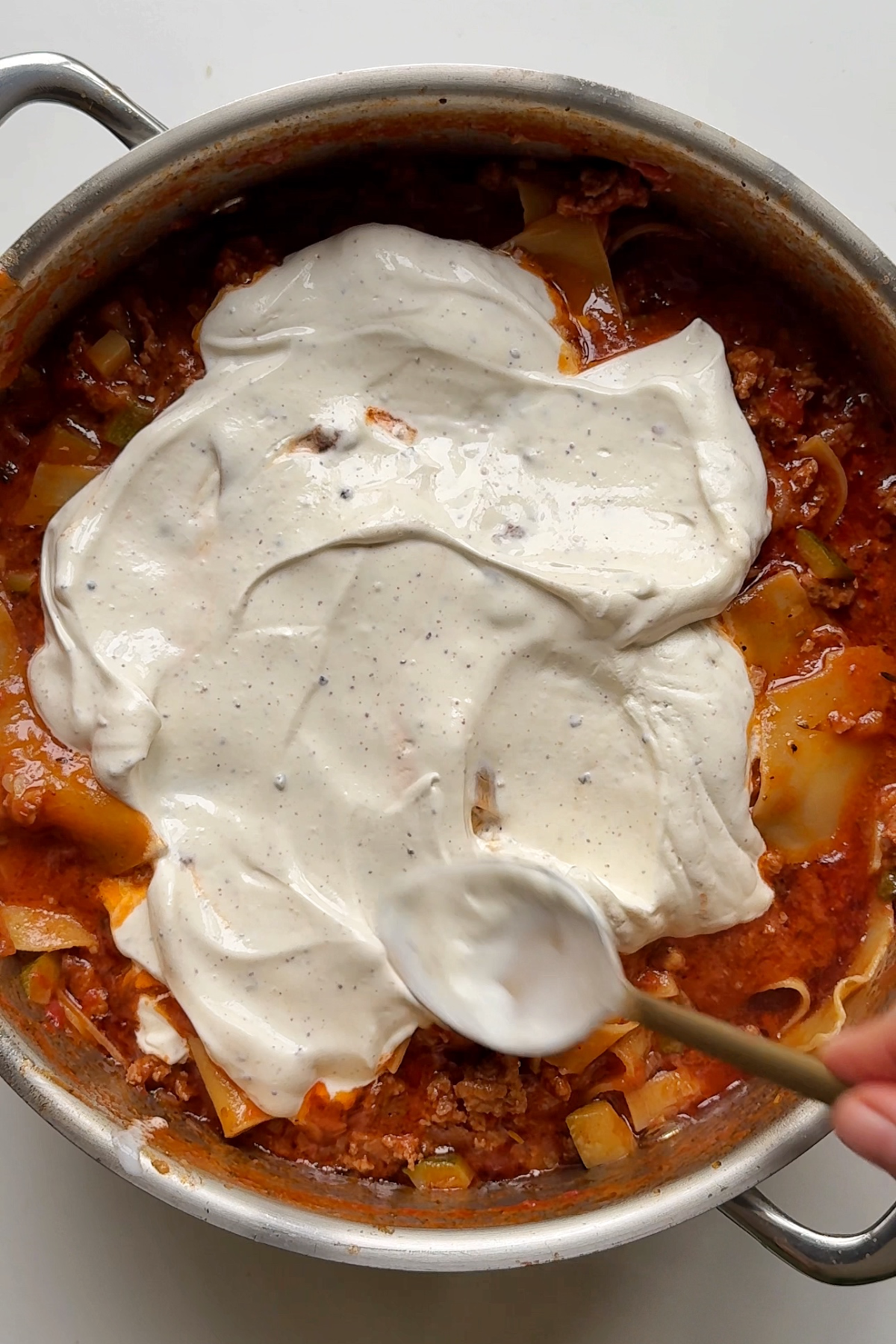Adding mascarpone to the one pot pasta dish.