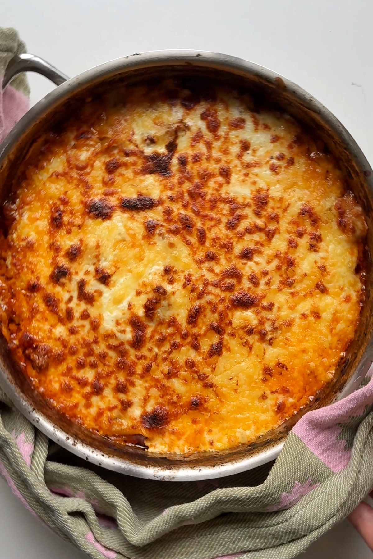 Adding one pot lasagna to the oven to grill the cheese.