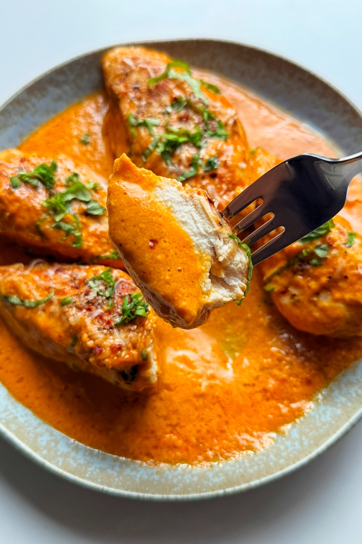 Close up of roasted red pepper chicken in a pan.