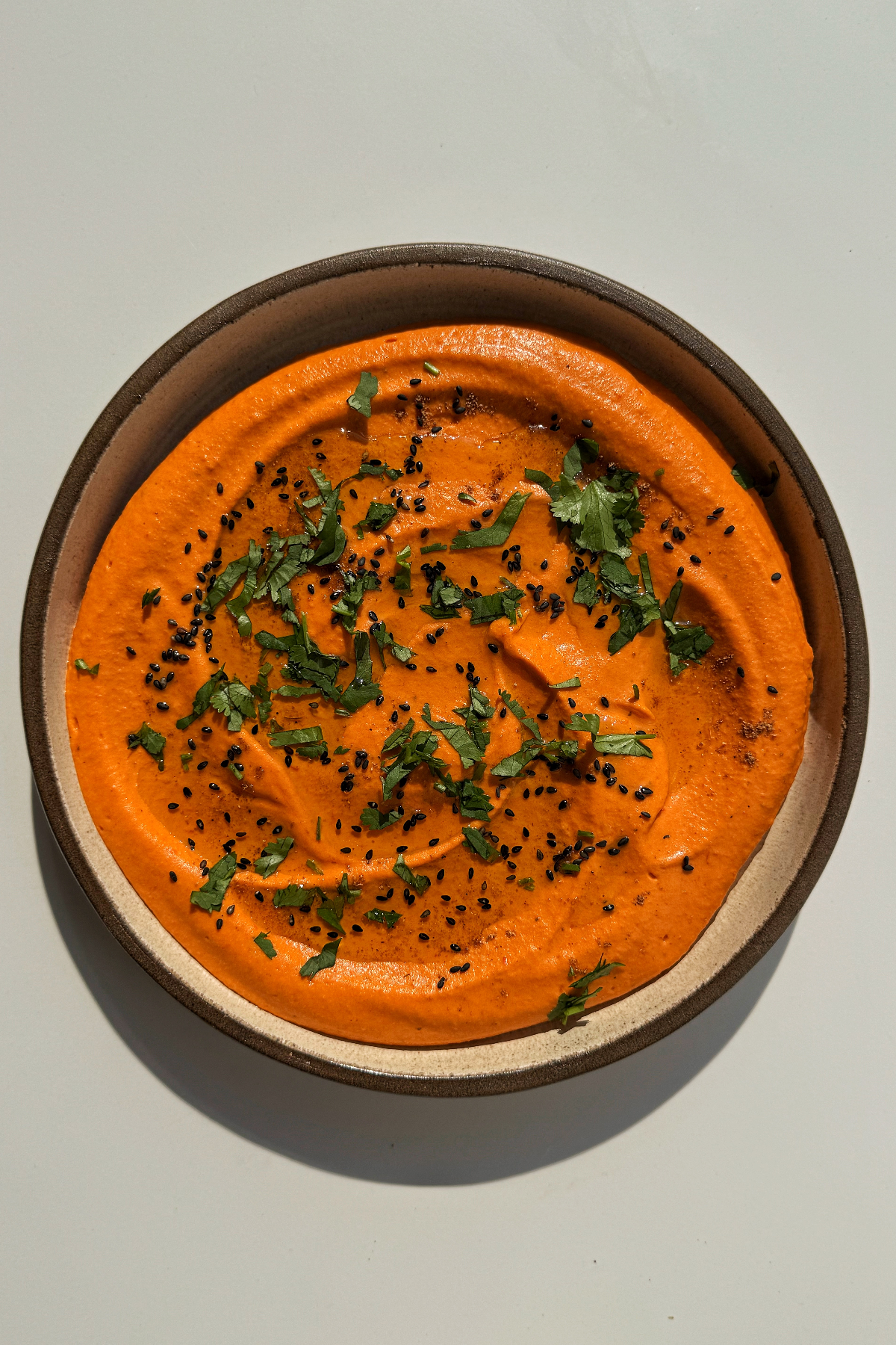 Roasted red pepper hummus on a plate.